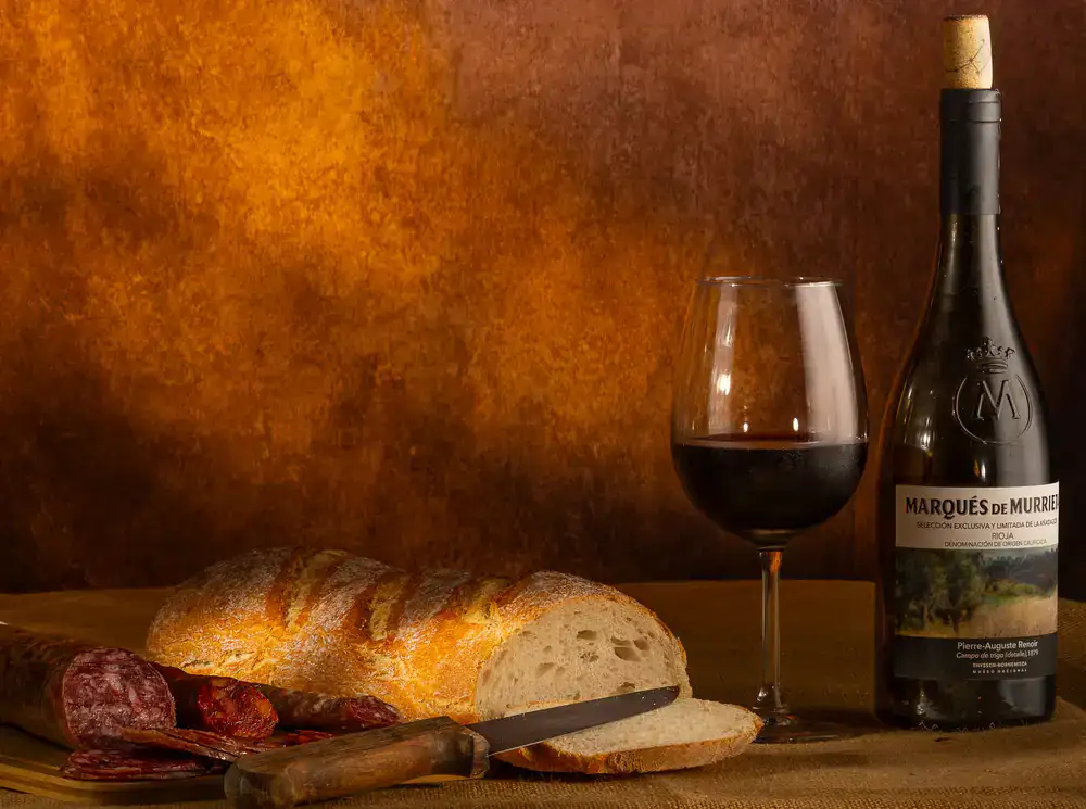 Bodegón de panes de masa madre recién horneados sobre mesa de madera rústica